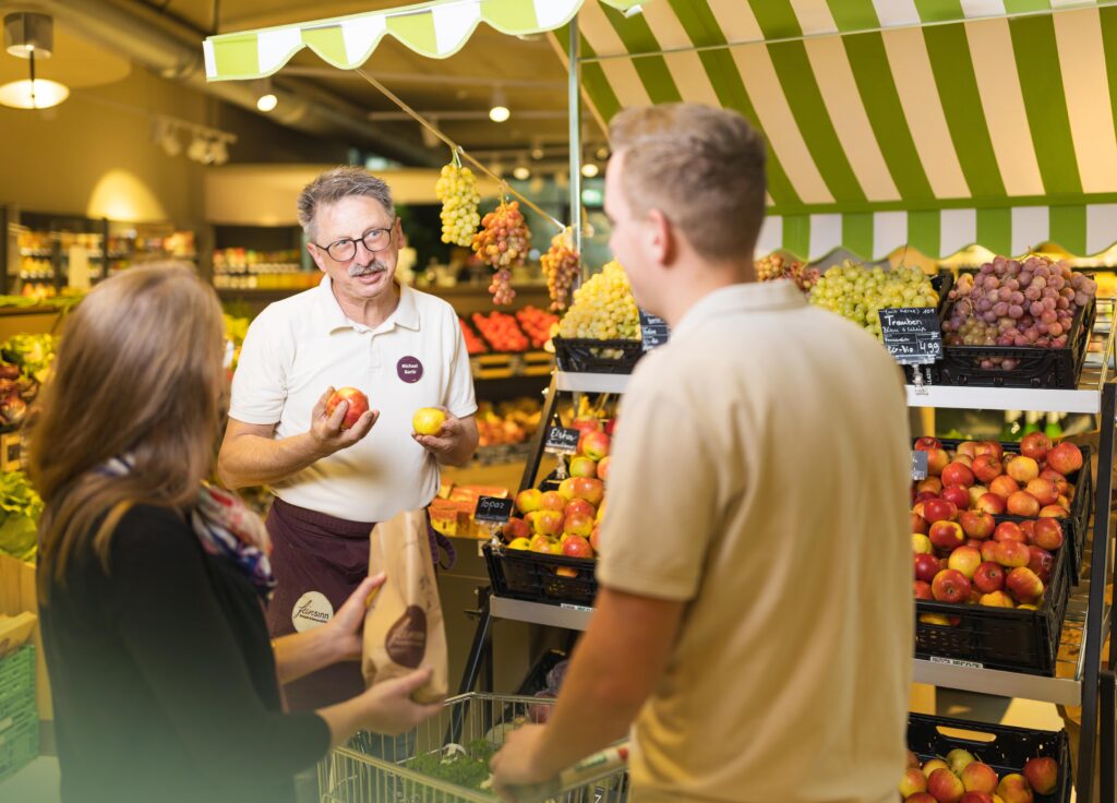 Feinsinn Mitarbeiter berät Kunden in der Obstabteilung
