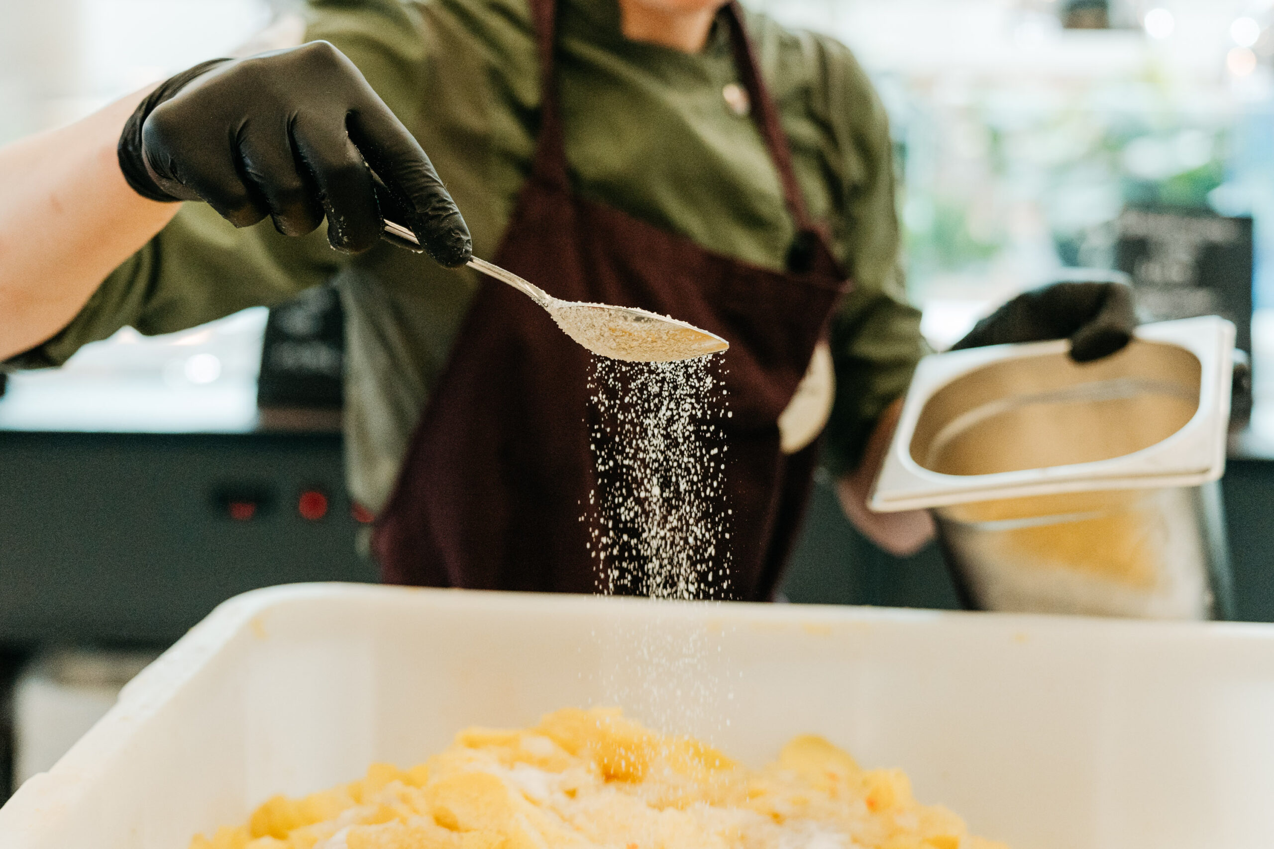 Köchin streut Salz über Kartoffeln